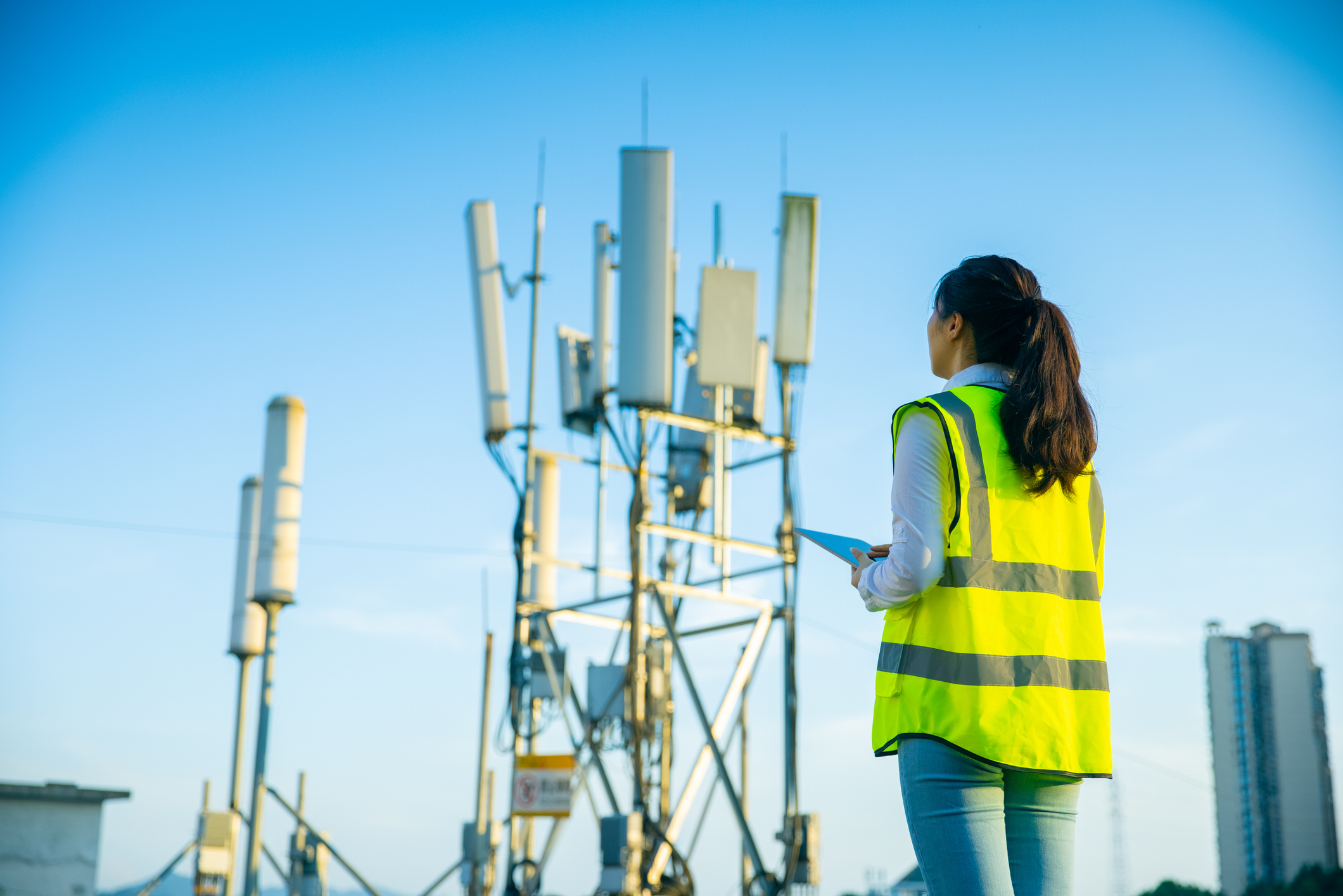 L'immagine rappresenta un ingegnere che lavora in una torre per le telecomunicazioni